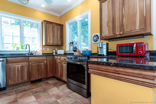 a kitchen with stainless steel appliances granite countertop a stove a sink and a microwave