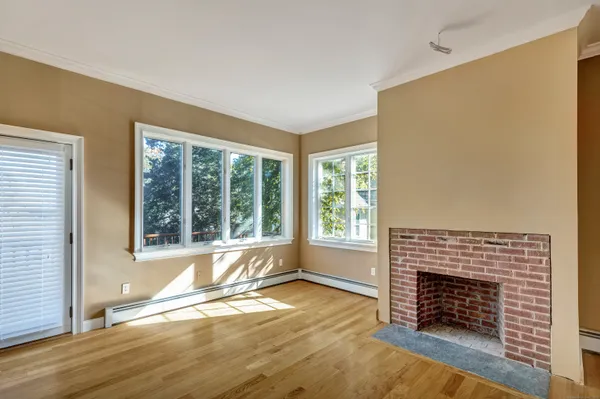 an empty room with fireplace and windows