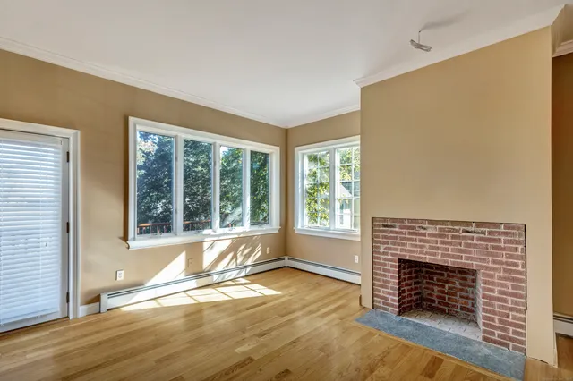 an empty room with fireplace and windows