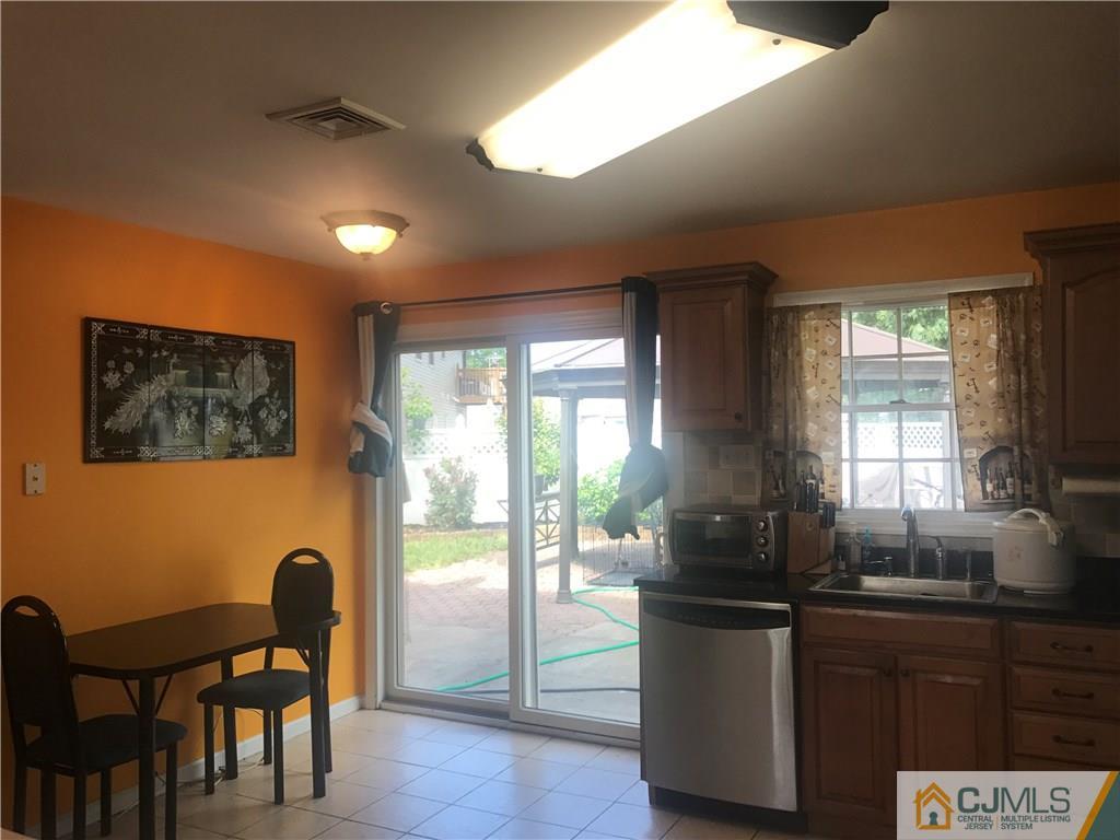 55 Knollwood Road Edison, NJ 08817 - Photo 14 of 25 a kitchen with stainless steel appliances granite countertop a table chairs in it and next to a window