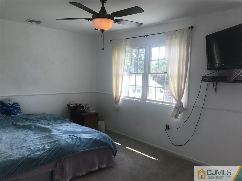 55 Knollwood Road Edison, NJ 08817 - Photo 19 of 25 a bedroom with a bed and a flat tv screen on the wall