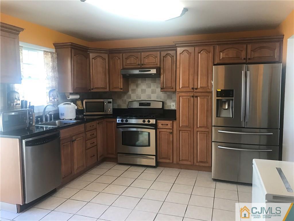55 Knollwood Road Edison, NJ 08817 - Photo 9 of 25 a kitchen with a refrigerator sink and cabinets