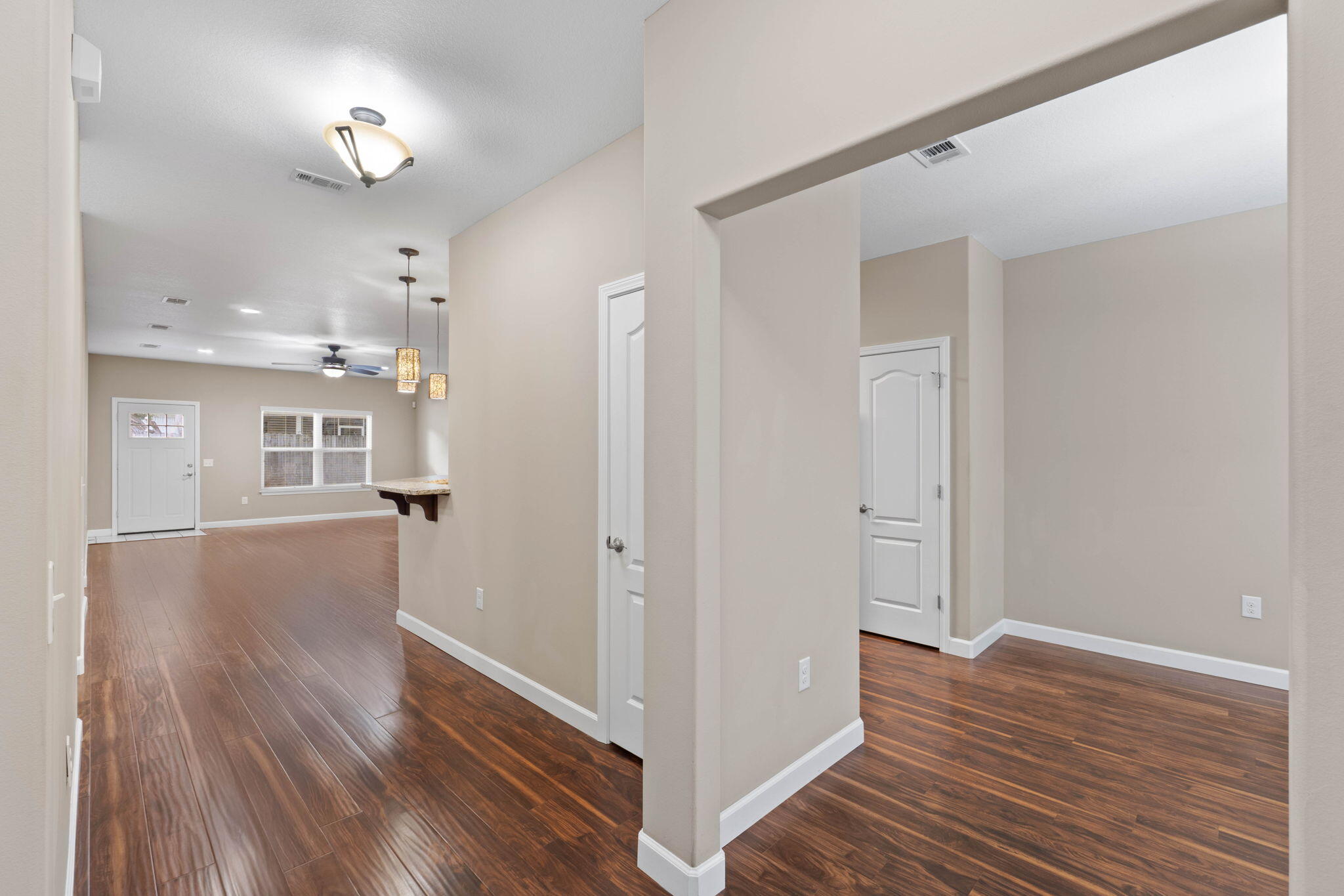 438 Brackin Street Crestview, FL 32539 - Photo 4 of 26 a view of a hallway with wooden floor and a kitchen