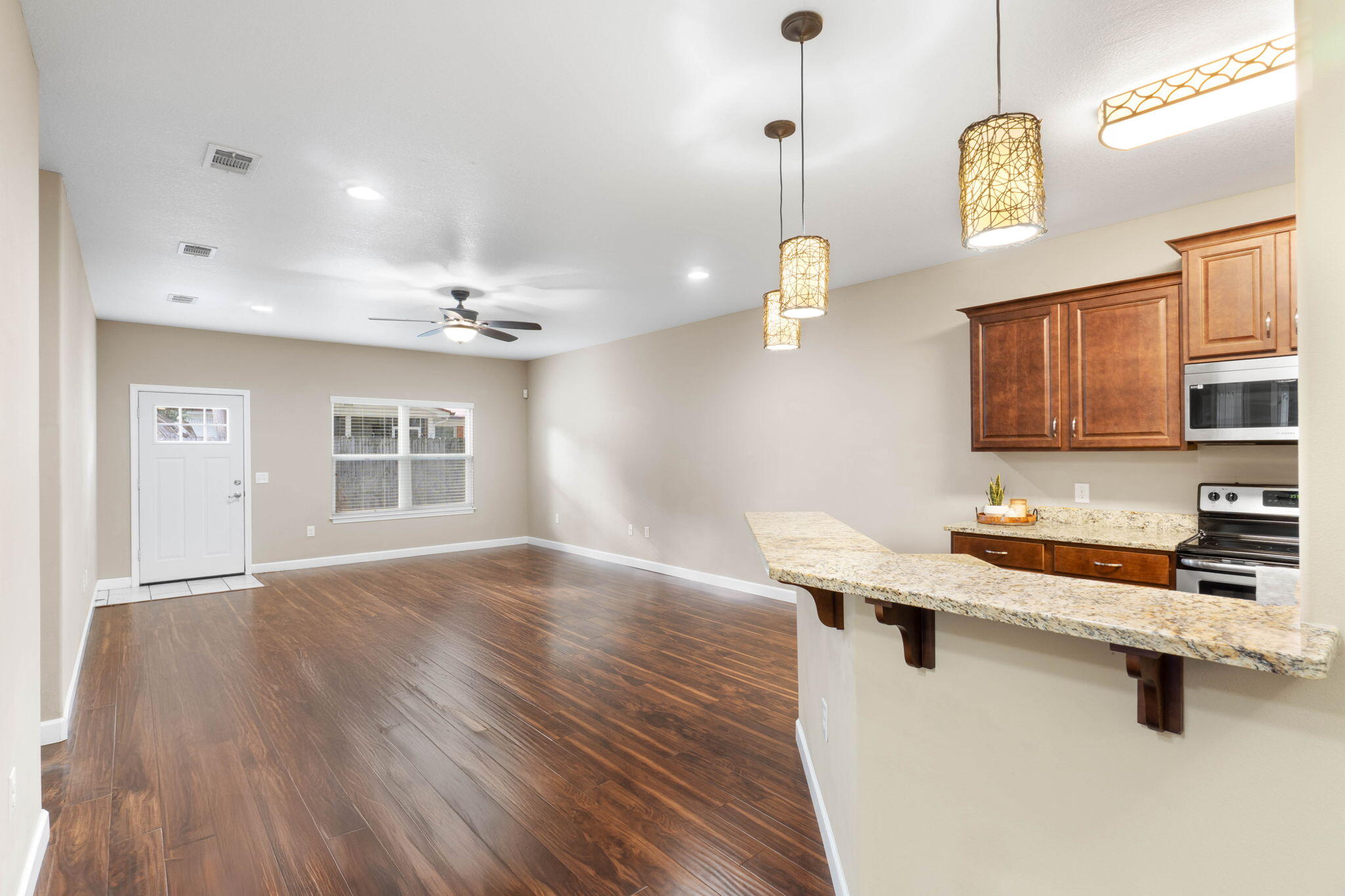 438 Brackin Street Crestview, FL 32539 - Photo 5 of 26 a room with a wooden floor and chandelier