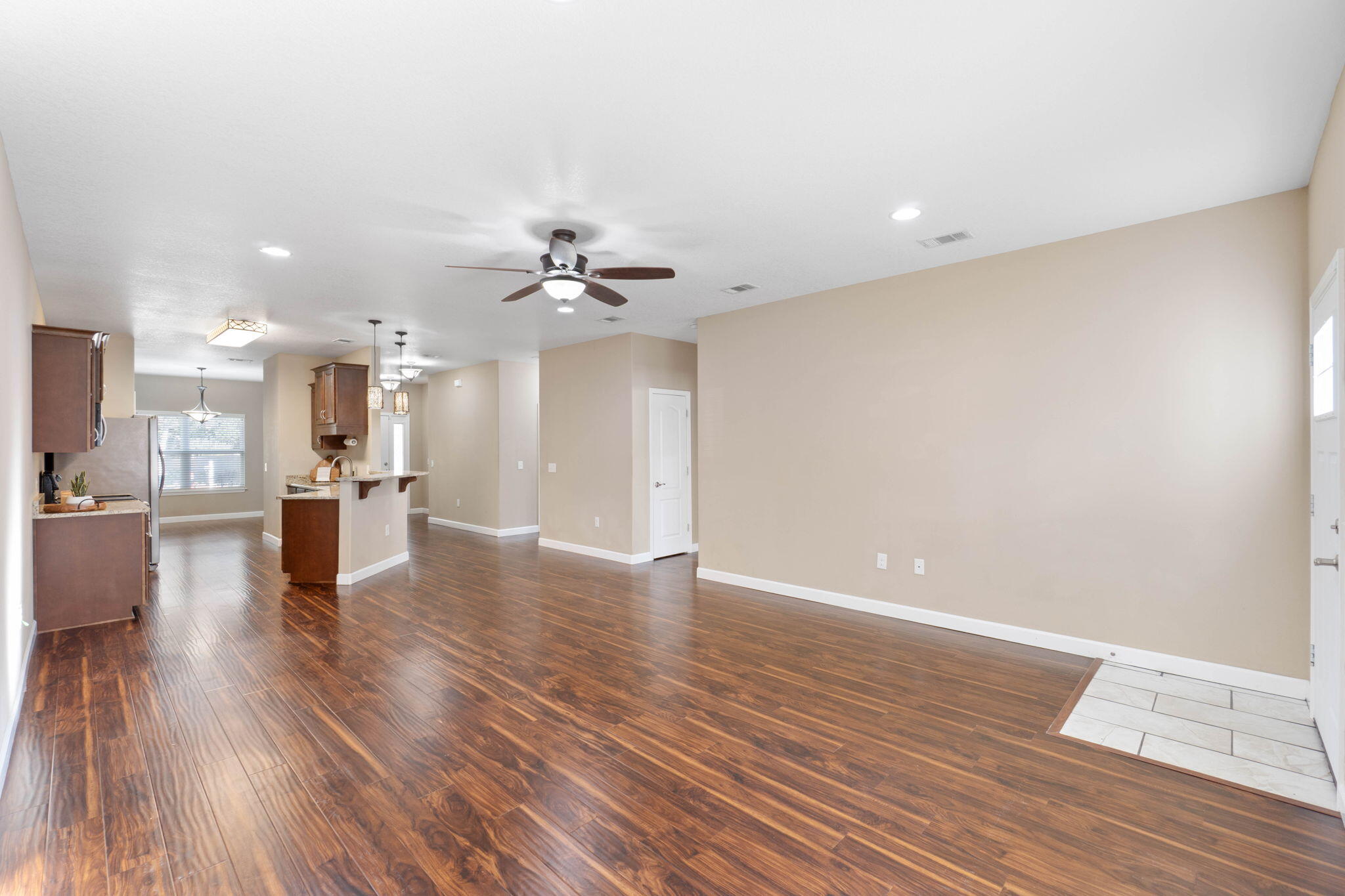438 Brackin Street Crestview, FL 32539 - Photo 6 of 26 a view of a big room with wooden floor and a kitchen