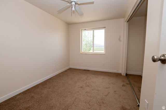 570 West Main Street Beaver, UT 84713 - Photo 14 of 43 Carpeted interior space featuring a ceiling fan with light fixture, a window offering exterior views, and a closet with sliding doors