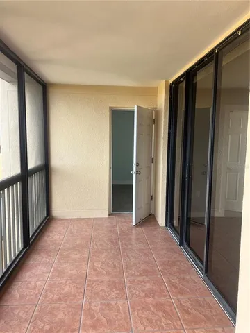 a view of an empty room with wooden floor and stairs