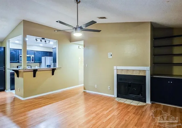 a view of a kitchen with wooden floor and a ceiling fan