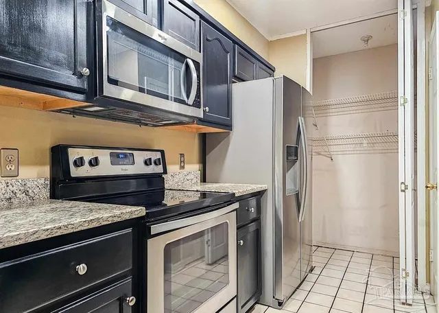 a kitchen with stainless steel appliances granite countertop a refrigerator and a stove