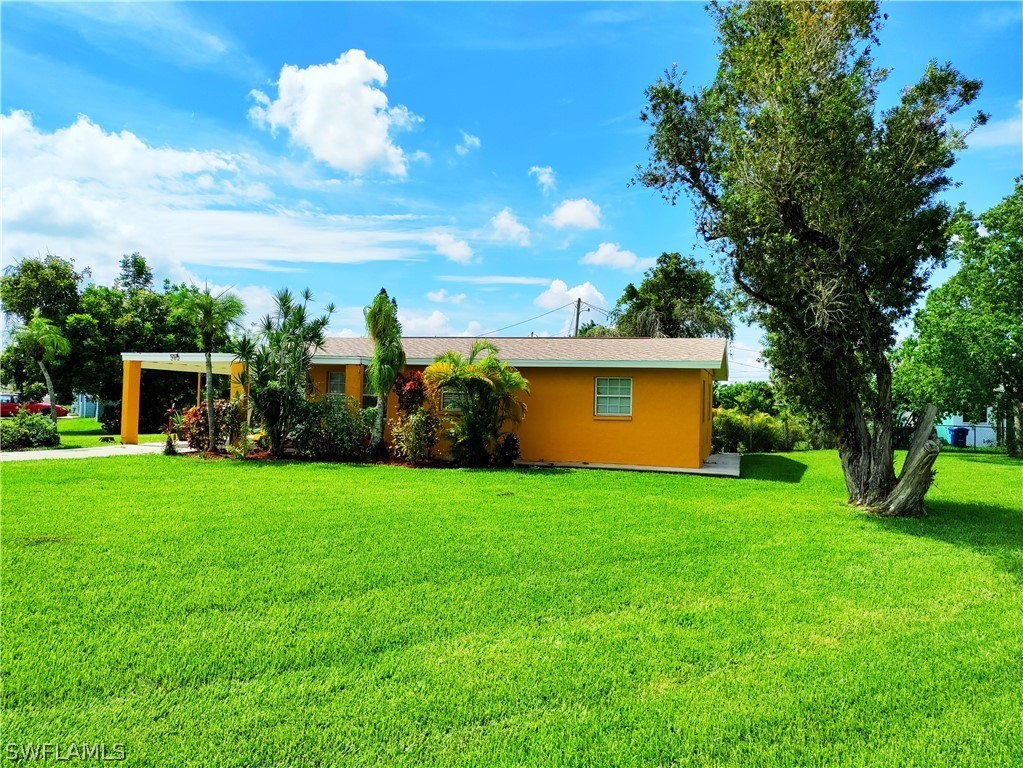 202 Davis Road Lehigh Acres, FL 33936 - Photo 14 of 16 a view of a house with a big yard