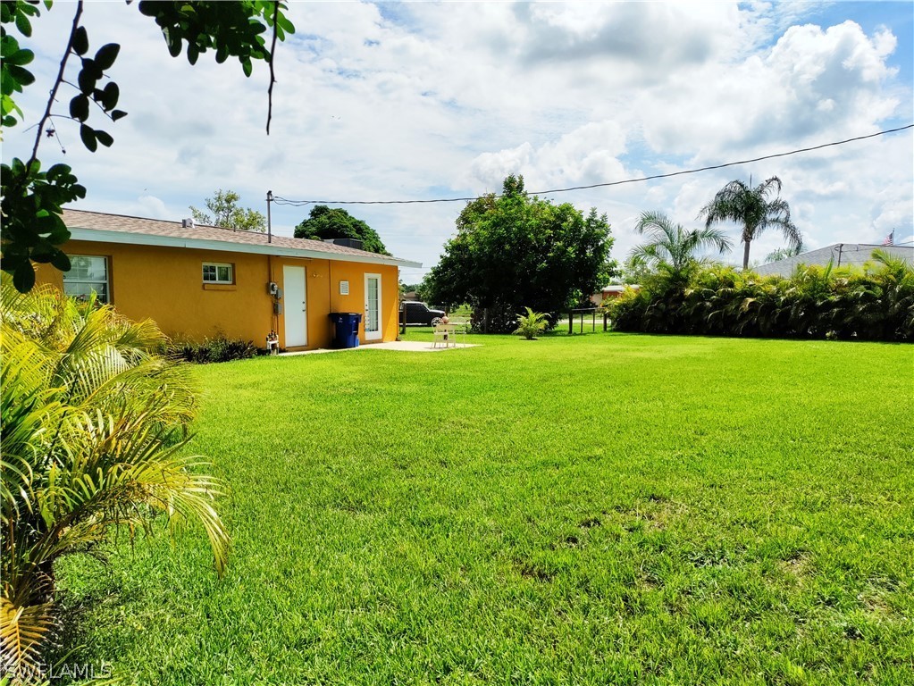 202 Davis Road Lehigh Acres, FL 33936 - Photo 16 of 16 a front view of a house with garden