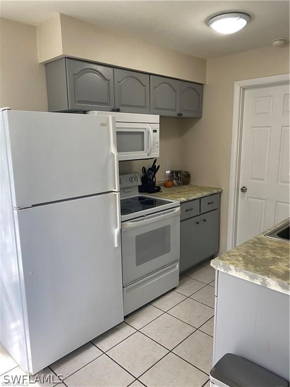 202 Davis Road Lehigh Acres, FL 33936 - Photo 5 of 16 a kitchen with a stove top oven and cabinets