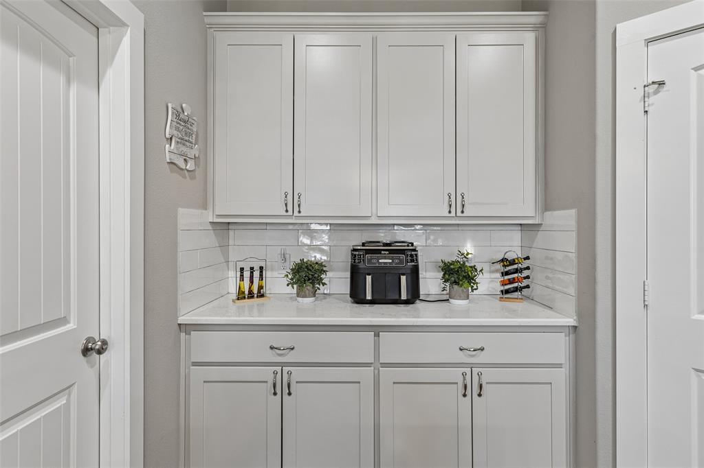 108 Maverick Lane Pilot Point, TX 76258 - Photo 10 of 27 White cabinetry with crown molding, subway tile backsplash, and a light-toned countertop