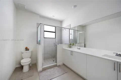 a bathroom with a double vanity sink toilet and shower