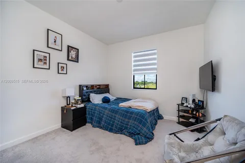 a bedroom with bed and a flat screen tv