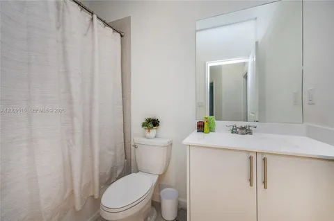 a bathroom with a granite countertop sink toilet and mirror