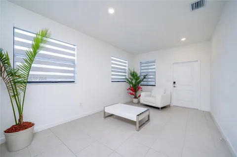 a living room with furniture and a potted plant