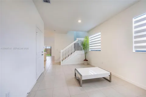 a hallway with a wooden floor and a potted plant