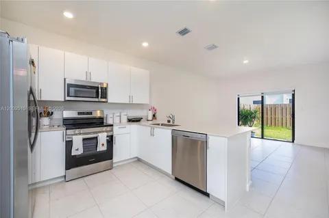 a kitchen with granite countertop a stove top oven and refrigerator