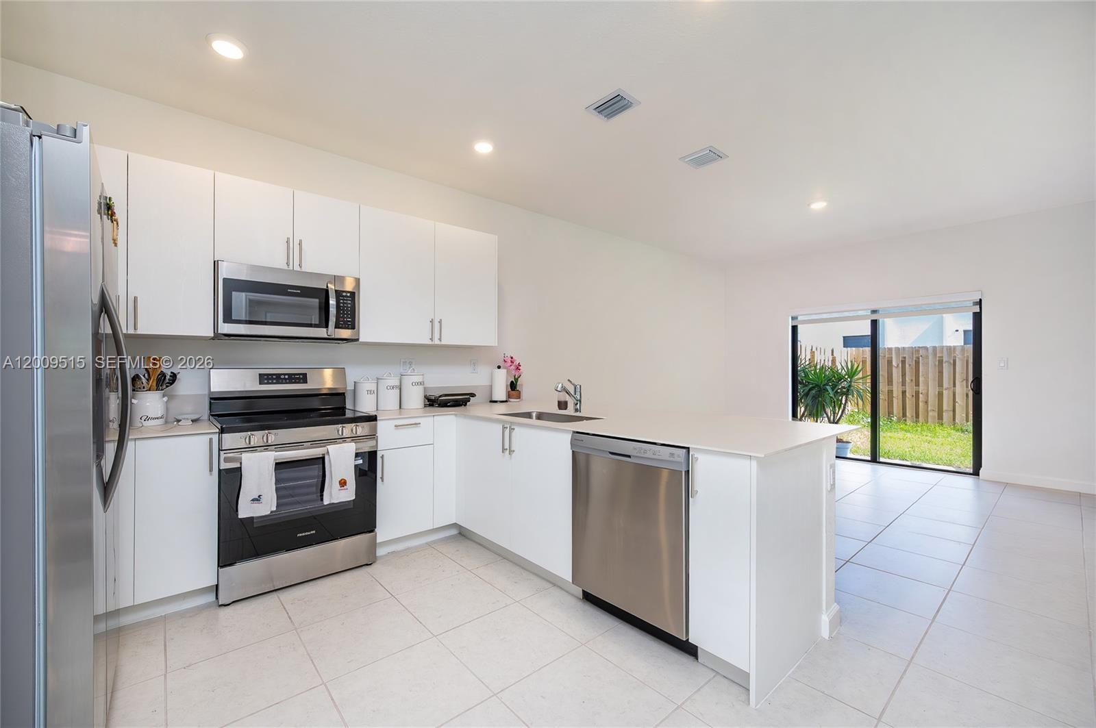 13311 Southwest 233rd Terrace Homestead, FL 33032 - Photo 6 of 21 a kitchen with granite countertop a stove top oven and refrigerator