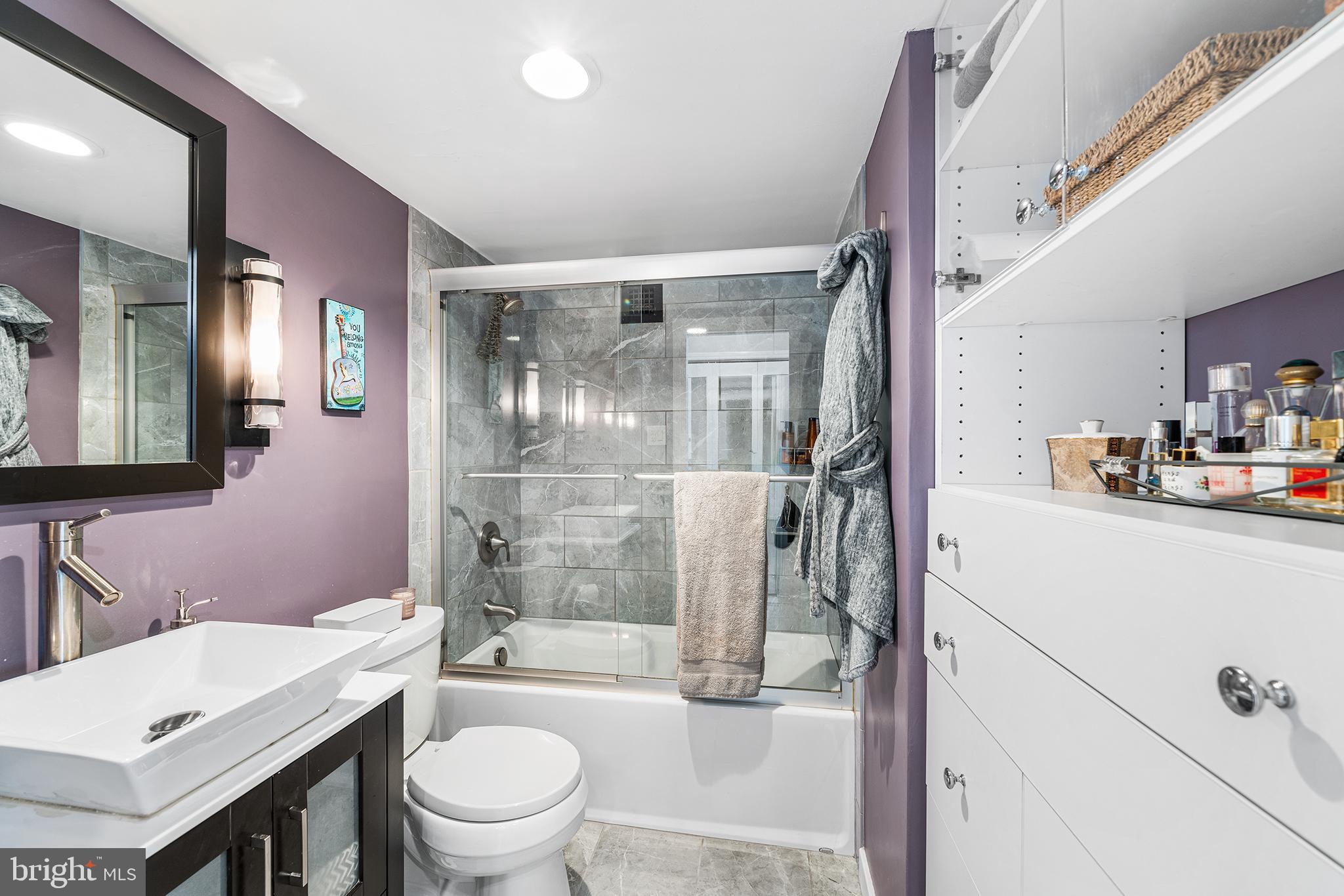 226-30 West Rittenhouse Square, Unit 2308 Philadelphia, PA 19103 - Photo 28 of 30 a bathroom with a granite countertop sink toilet a mirror and shower
