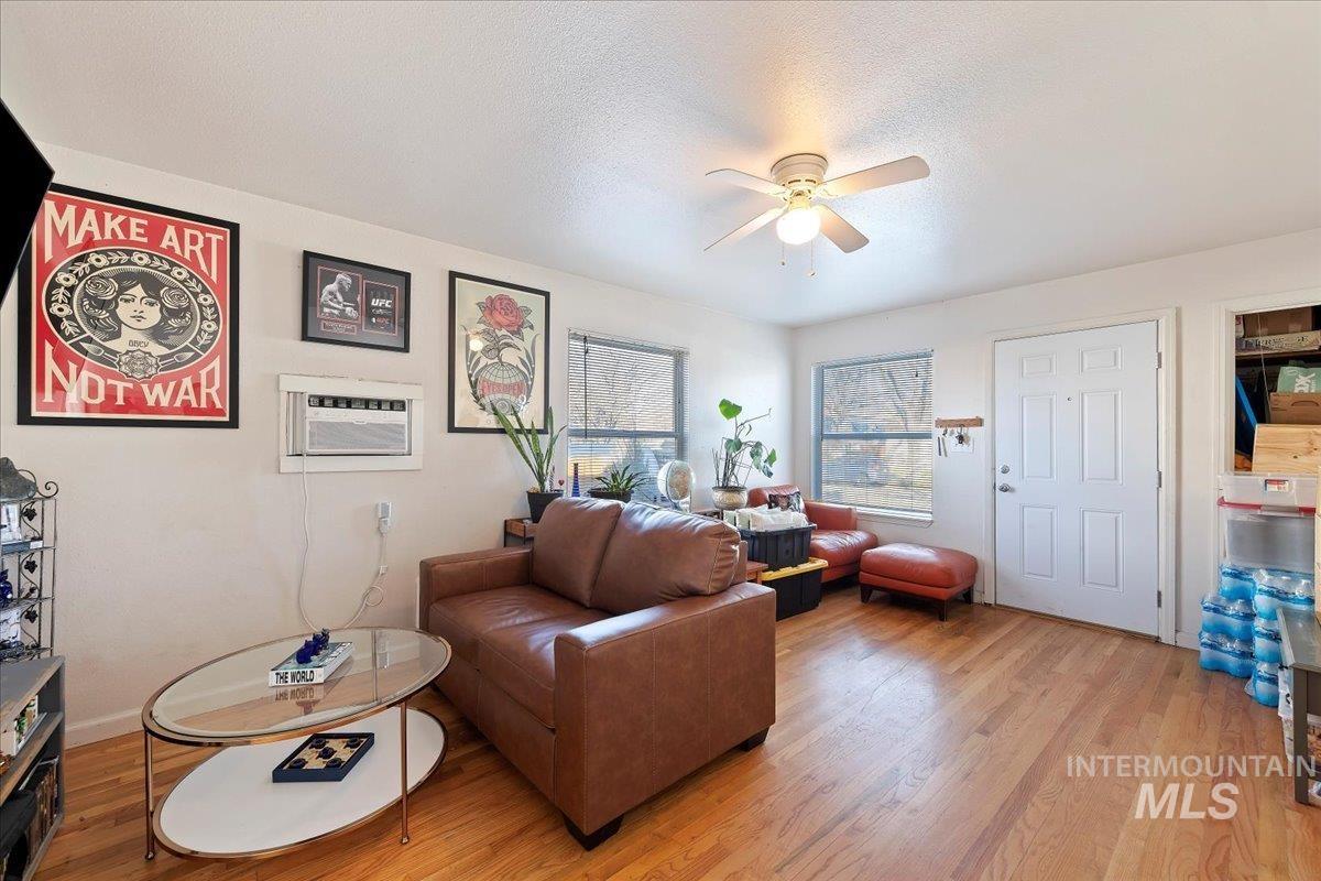 2209 West Idaho Street Boise, ID 83702 - Photo 5 of 42 Living room with a textured ceiling, a ceiling fan, light wood finished floors, and an AC wall unit