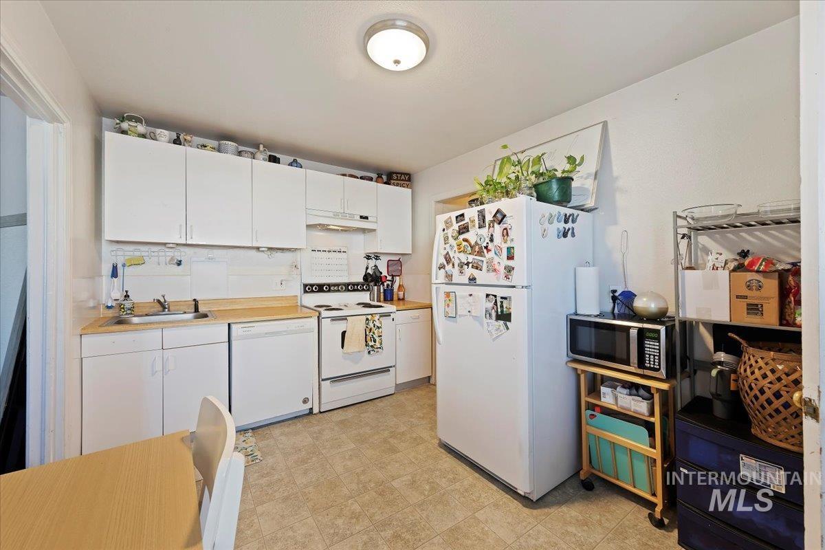 2209 West Idaho Street Boise, ID 83702 - Photo 6 of 42 Kitchen with white cabinets, white appliances, light countertops, and under cabinet range hood
