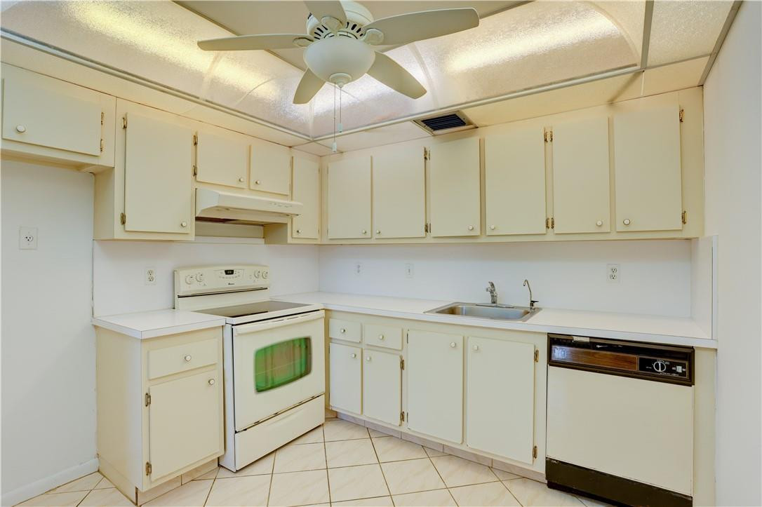 1903 Bermuda Circle, Unit E2 Coconut Creek, FL 33066 - Photo 11 of 25 a kitchen with white cabinets stainless steel appliances and sink