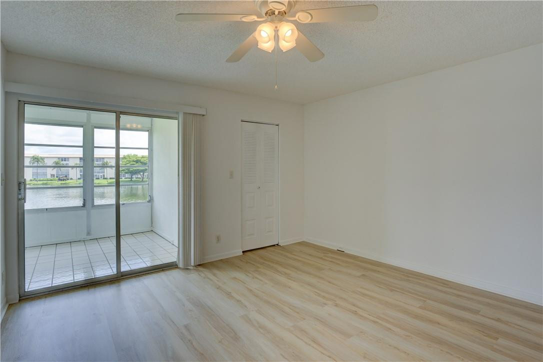 1903 Bermuda Circle, Unit E2 Coconut Creek, FL 33066 - Photo 14 of 25 wooden floor in an empty room with a window