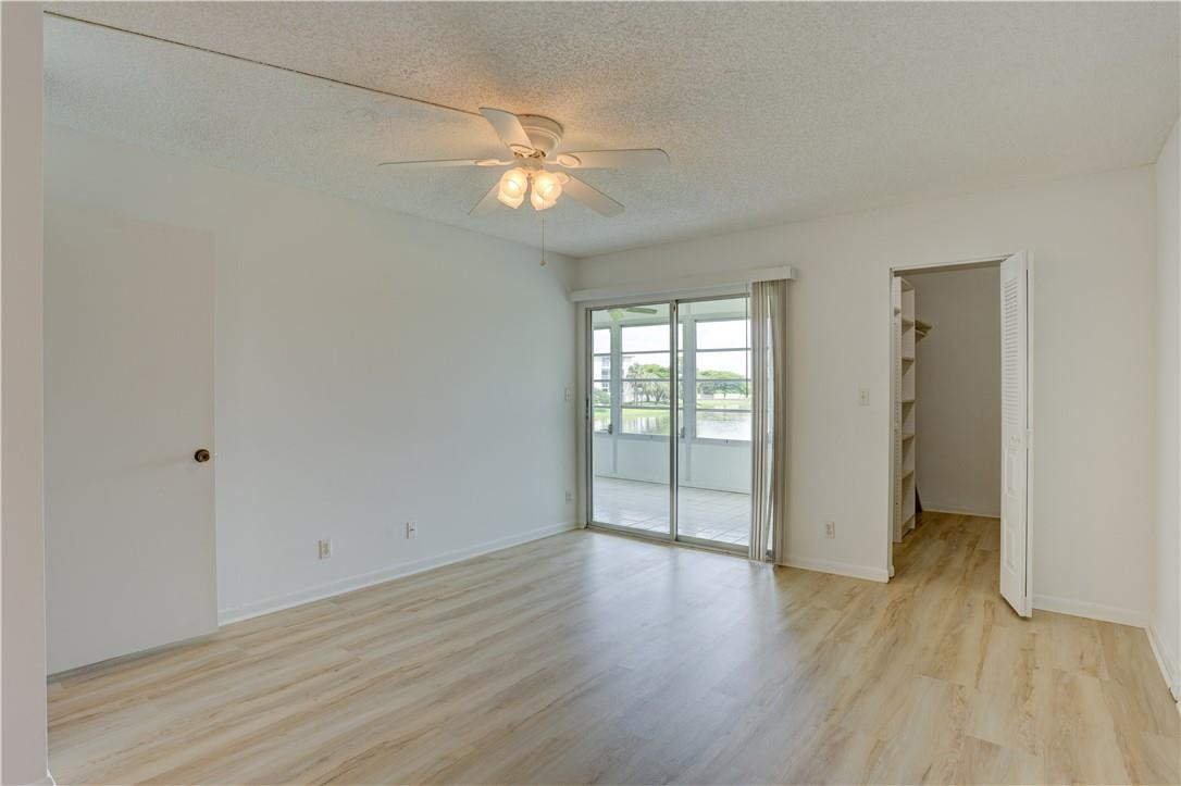 1903 Bermuda Circle, Unit E2 Coconut Creek, FL 33066 - Photo 16 of 25 wooden floor in an empty room with a window