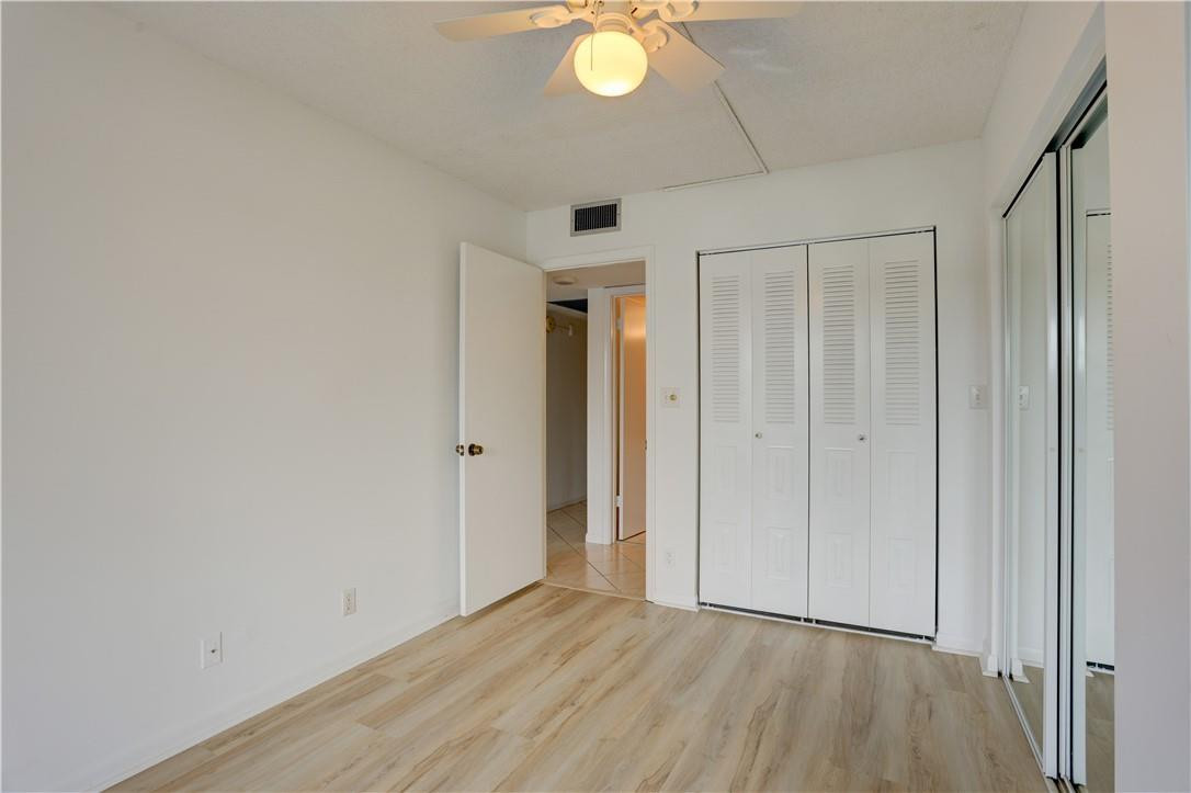 1903 Bermuda Circle, Unit E2 Coconut Creek, FL 33066 - Photo 20 of 25 a view of an empty room with wooden floor and a window