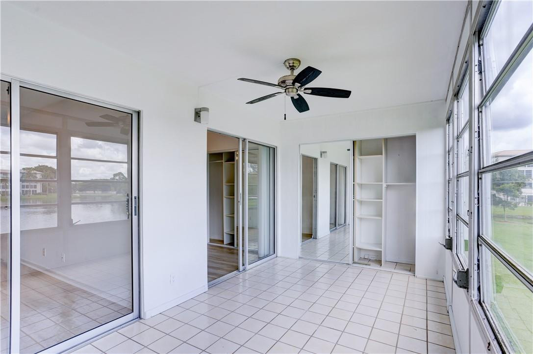 1903 Bermuda Circle, Unit E2 Coconut Creek, FL 33066 - Photo 22 of 25 a view of empty room with wooden floor and fan