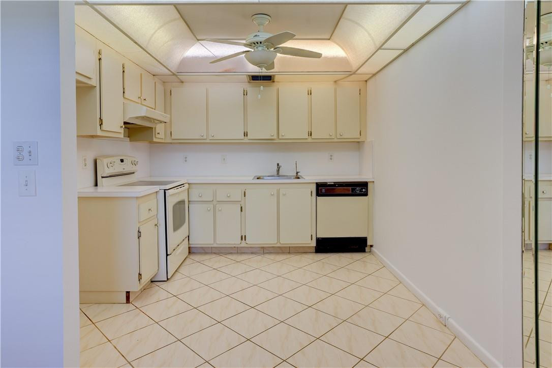 1903 Bermuda Circle, Unit E2 Coconut Creek, FL 33066 - Photo 9 of 25 a kitchen with a sink cabinets and a window