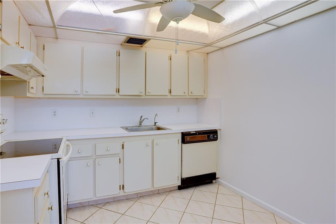 1903 Bermuda Circle, Unit E2 Coconut Creek, FL 33066 - Photo 10 of 25 a kitchen with white cabinets and white appliances