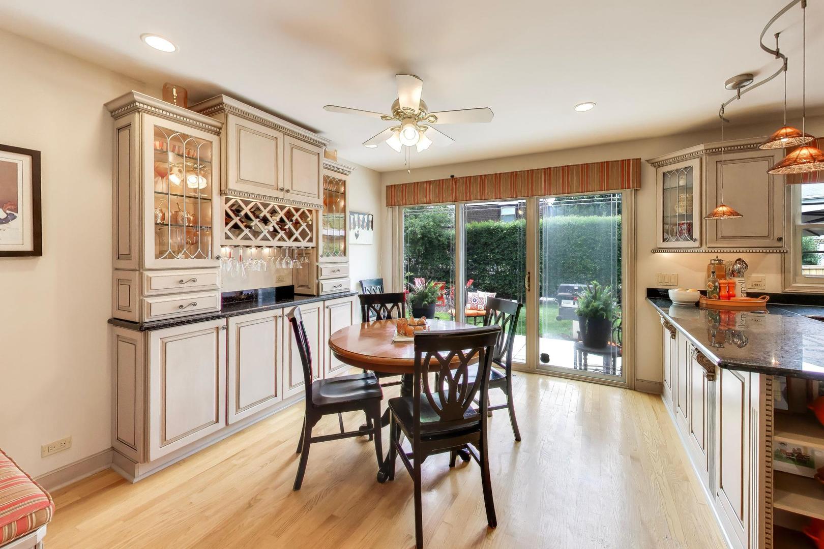 3956 Rutgers Lane Northbrook, IL 60062 - Photo 11 of 41 a open dining room with stainless steel appliances kitchen island granite countertop a stove a refrigerator a dining table and chairs with wooden floor