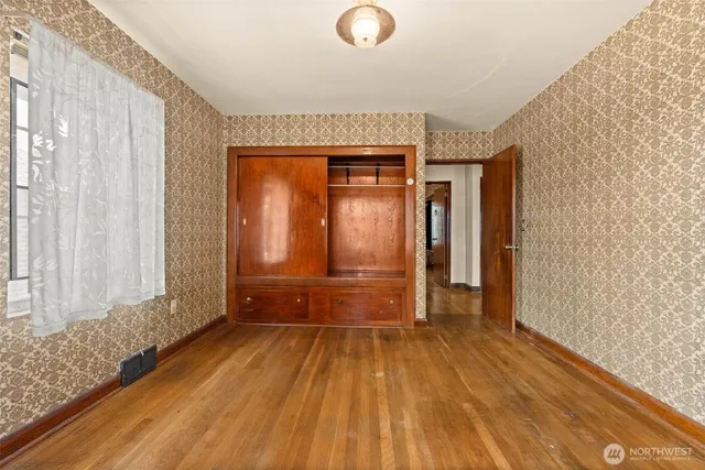 a view of a room with wooden floor and doors