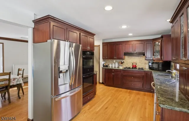 a kitchen with granite countertop a refrigerator and a sink