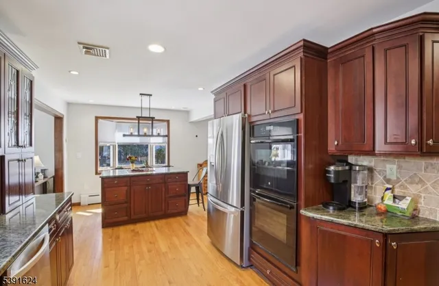 a kitchen with granite countertop stainless steel appliances and wooden cabinets