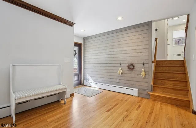 a view of a hallway with wooden floor and staircase