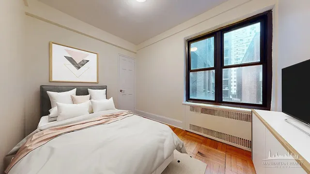 a bedroom with a bed and a large window