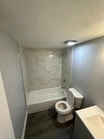 a bathroom with a toilet a sink and bathtub