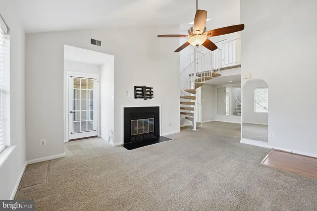 a view of empty room with fireplace and fan