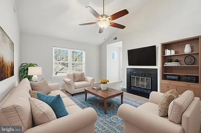 a living room with furniture a fireplace and a flat screen tv