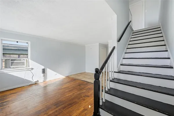a view of staircase with wooden floor and white walls
