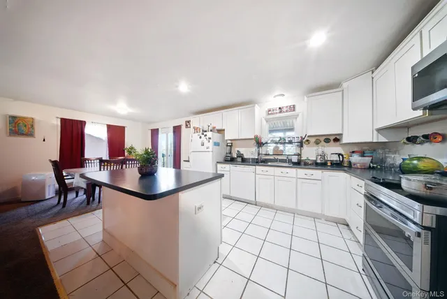 a kitchen with stainless steel appliances kitchen island granite countertop a sink and cabinets