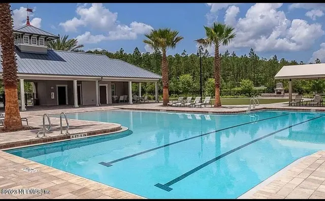 a view of a house with pool and chairs