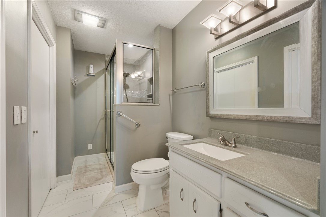 624 Locke Street Alma, AR 72921 - Photo 13 of 32 Full bathroom featuring a glass-enclosed shower, white vanity with an integrated sink, and a light-toned countertop