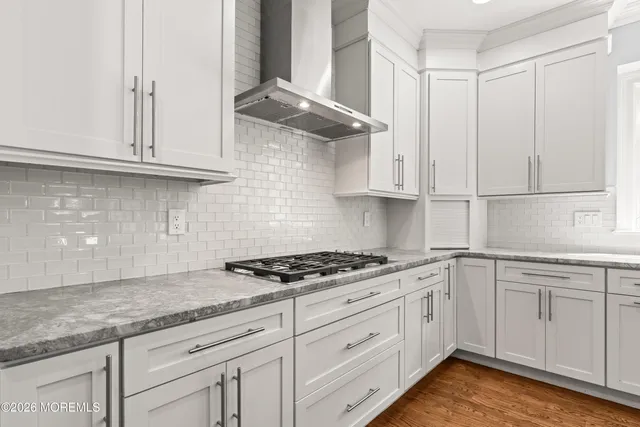 a dining room with stainless steel appliances kitchen island granite countertop a table chairs and a living room view