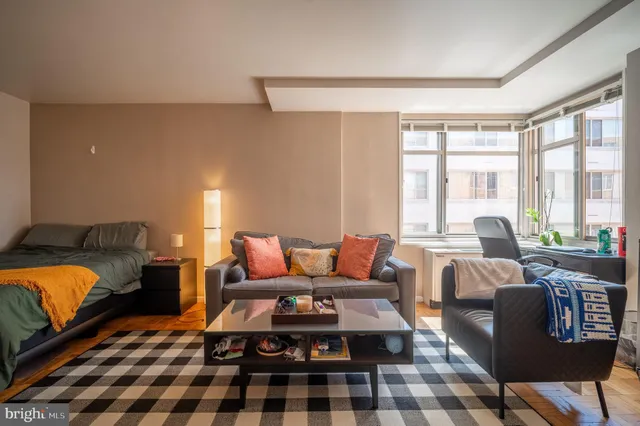 a living room with furniture fireplace and a large window