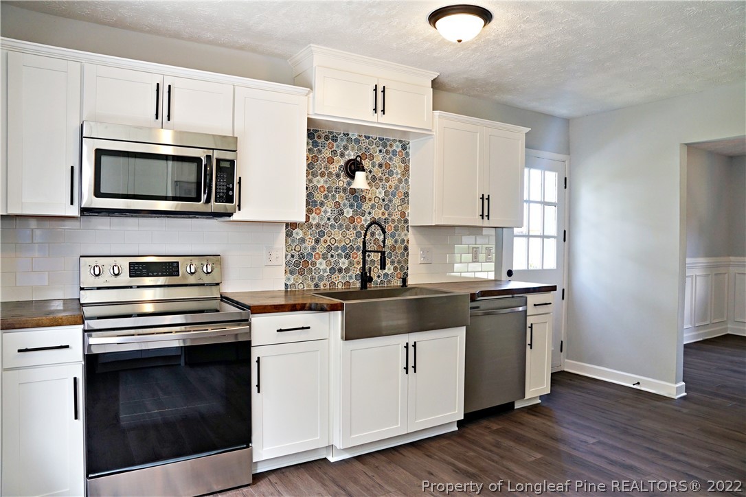 197 Paddle Wheel Road Fayetteville, NC 28314 - Photo 14 of 39 a kitchen with cabinets stainless steel appliances and wooden floor